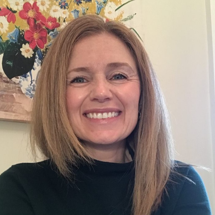 a headshot of a woman with light brown hair smiling wearing a black turtleneck shirt